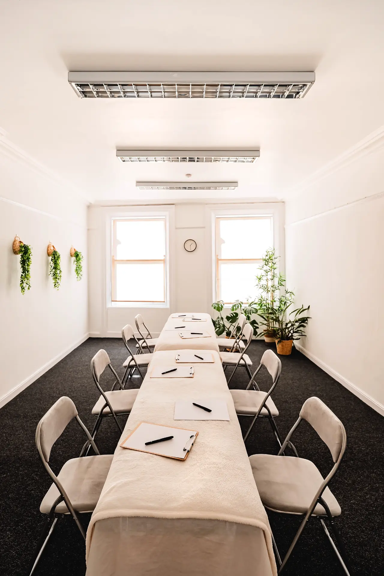 Brigid Room set up boardroom style with a long draped table, clipboards and folding chairs