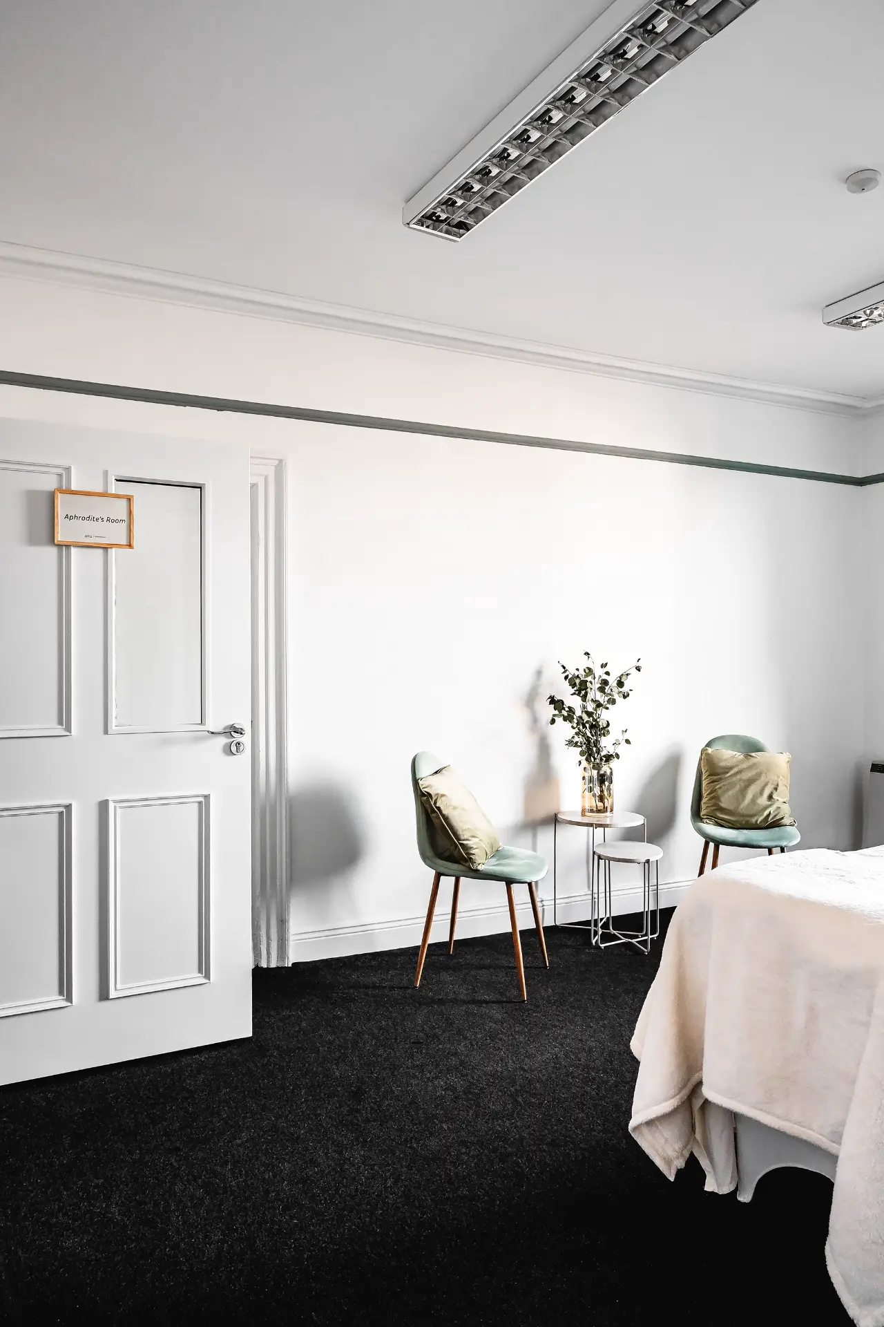Aphrodite's Room doorway with treatment couch and sage green chairs